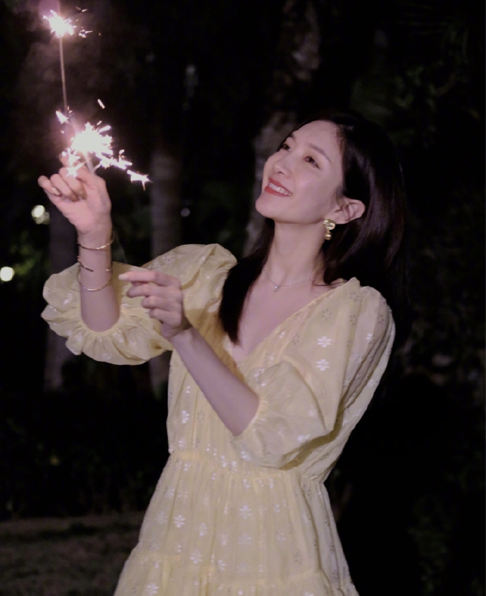 江疏影玩烟花棒笑容甜美 穿黄色长裙似仙女