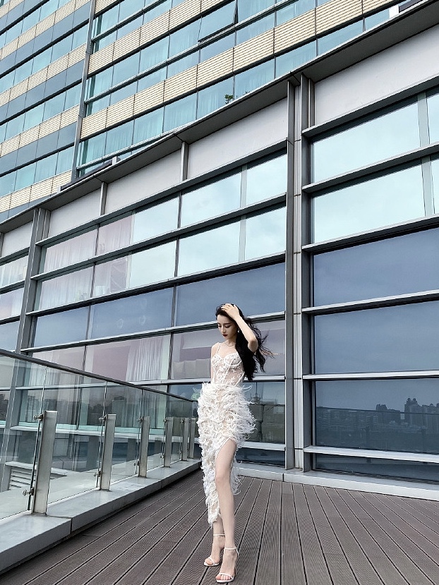 迪丽热巴穿镂空羽毛裙秀长腿 美背撩人