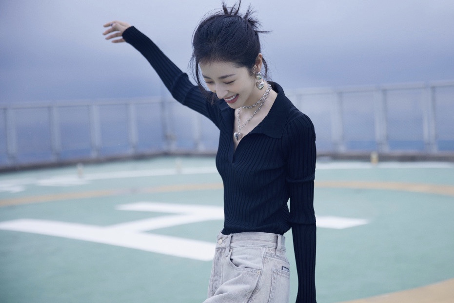 周雨彤穿V领黑衫秀锁骨 低头灿笑侧颜精致