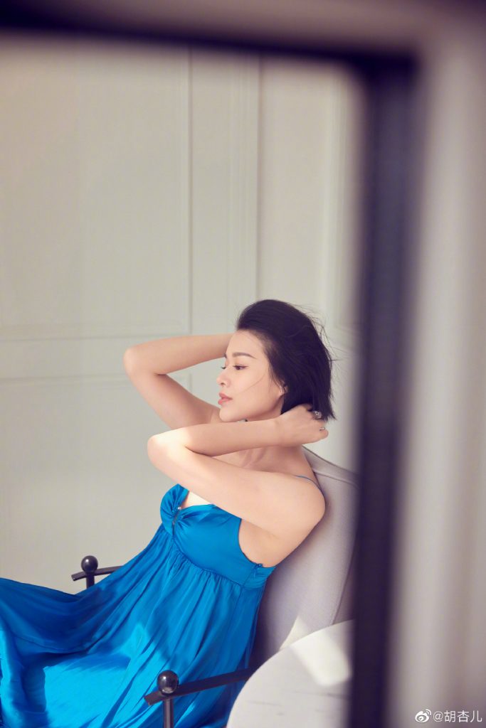 胡杏儿穿孔雀蓝长裙拍照 淡妆精致短发撩人