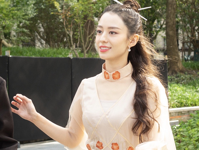吉娜穿粉纱裙梳发髻插＂筷子＂ 造型别致吸睛