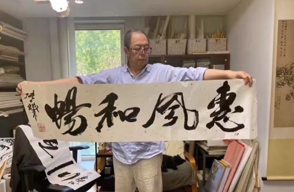 64岁张铁林书房里练字!头上扎小辫肚腩突出,满屋堆满书画显拥挤