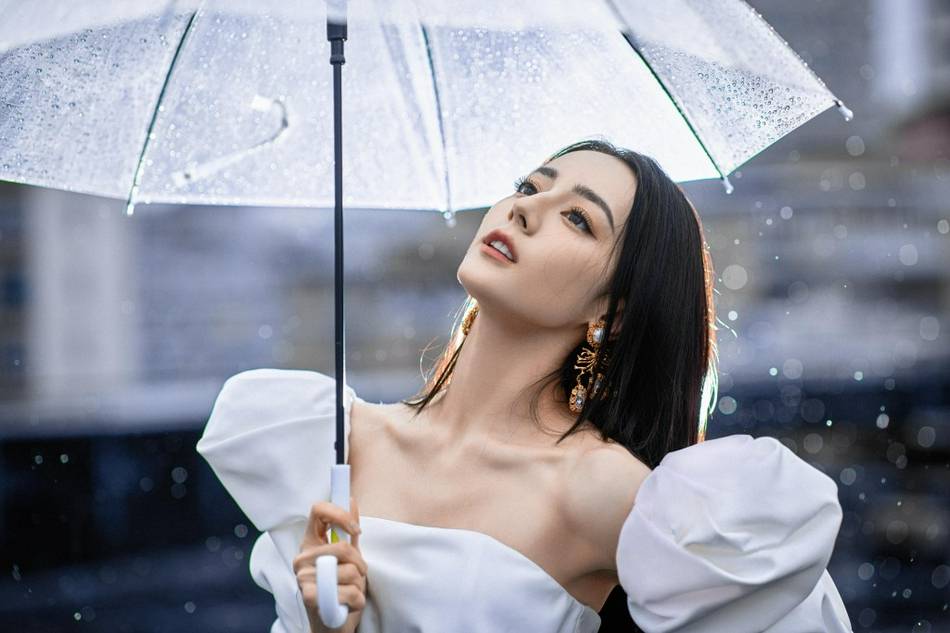 迪丽热巴穿抹胸裙秀美腿 伫立雨中氛围感强
