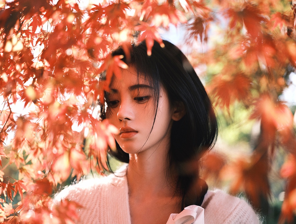 鞠婧祎穿白色针织上衣戴耳机 尽显文艺气质