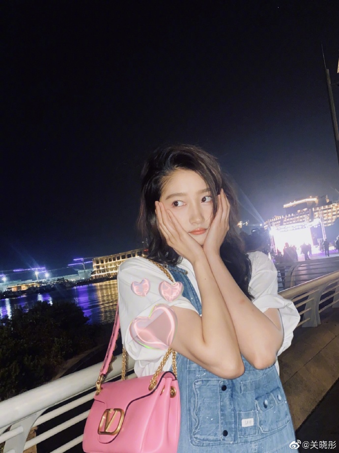 关晓彤穿背带裤坐路边开心尝美食 可爱满分