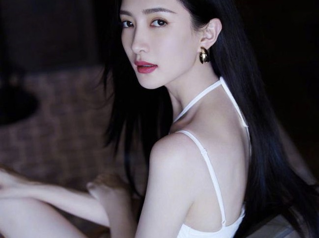 江疏影穿挂脖装拍写真，坐在凳子上秀曲线美