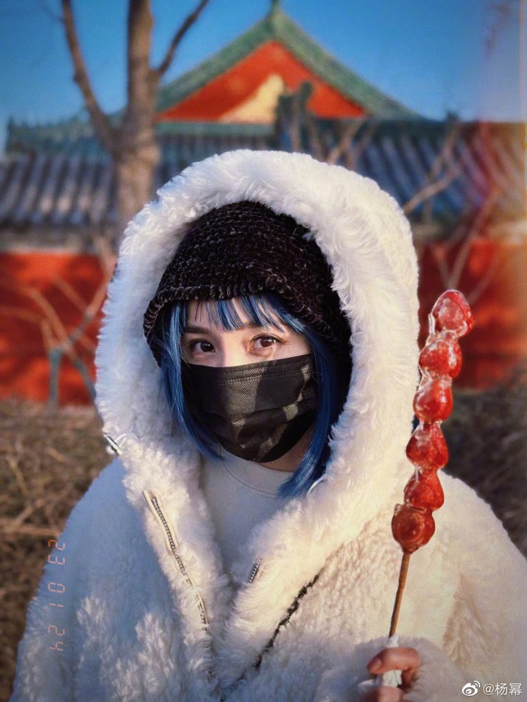 杨幂蓝色短发造型曝光 吃糖葫芦游玩什刹海